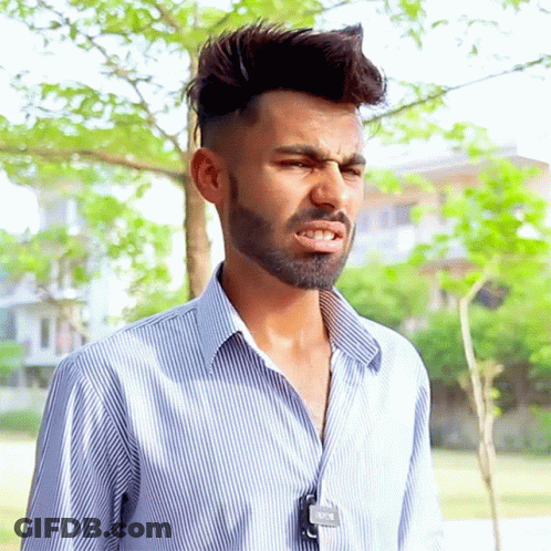 A Man With A Beard Wearing A Striped Shirt Has A Tag Around His Neck That Says ' A ' On It GIF