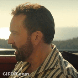 A Man With A Beard Wearing A Striped Shirt Looks To The Side GIF