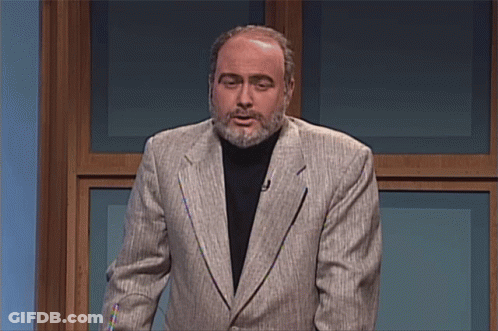 A Man With A Beard Wearing A Suit And A Black Turtleneck GIF