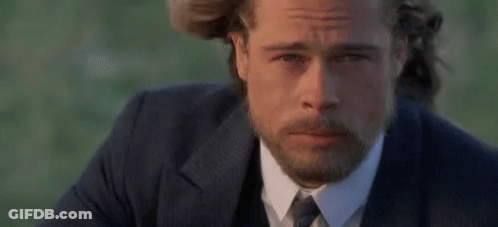 A Man With A Beard Wearing A Suit And Tie Is Looking At The Camera . GIF