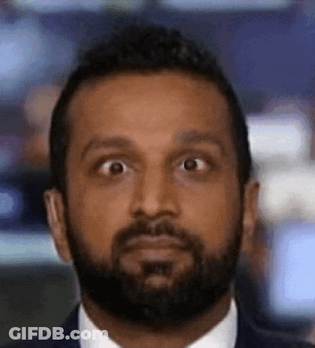 A Man With A Beard Wearing A Suit And Tie Is Making A Funny Face GIF