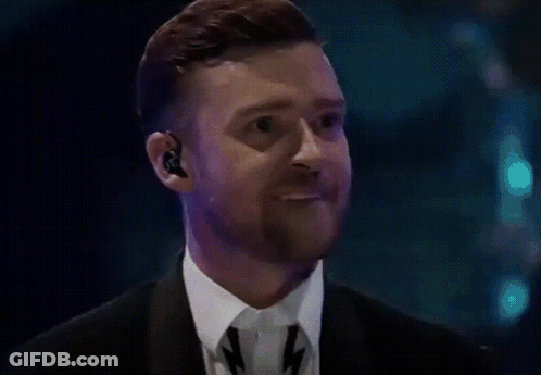 A Man With A Beard Wearing A Suit And Tie Is Making A Funny Face GIF