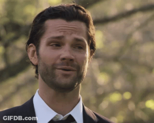 A Man With A Beard Wearing A Suit And Tie Is Smiling GIF