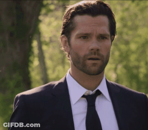 A Man With A Beard Wearing A Suit And Tie Looks Surprised GIF