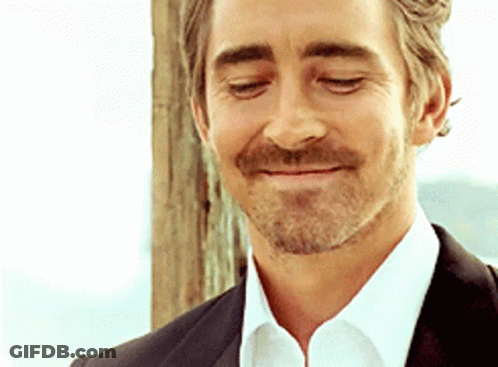 A Man With A Beard Wearing A Suit And White Shirt Is Smiling With His Eyes Closed GIF