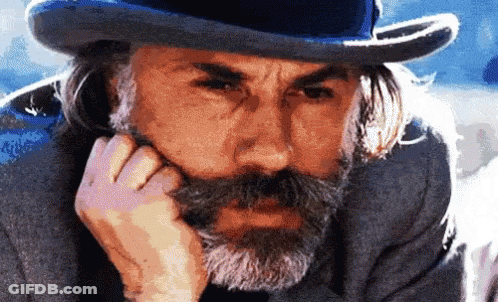 A Man With A Beard Wearing A Top Hat And A Gray Suit GIF