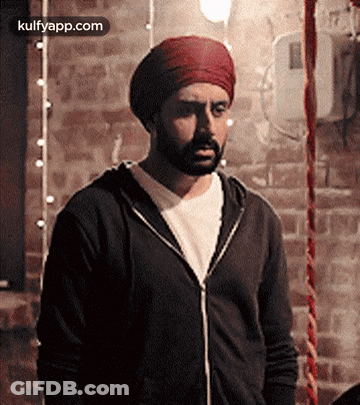 A Man With A Beard Wearing A Turban And A Black Jacket GIF