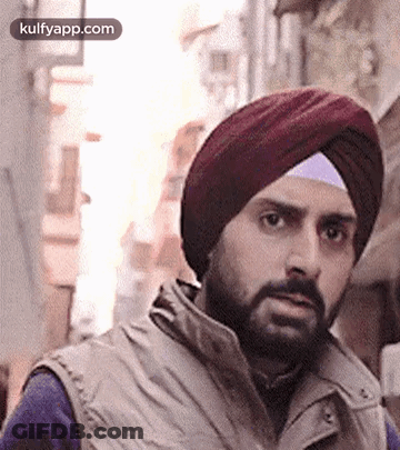A Man With A Beard Wearing A Turban And A Vest . GIF