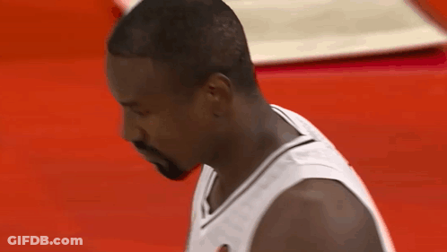 A Man With A Beard Wearing A White Jersey Looks Down At Something GIF
