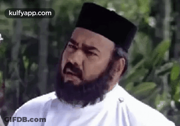 A Man With A Beard Wearing A White Shirt And A Black Hat . GIF