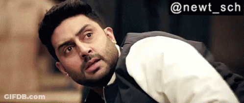 A Man With A Beard Wearing A White Shirt And A Black Vest Is Looking Up . GIF