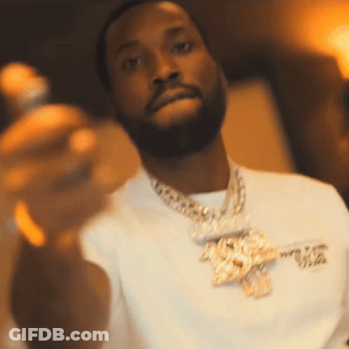 A Man With A Beard Wearing A White Shirt And Gold Chains GIF