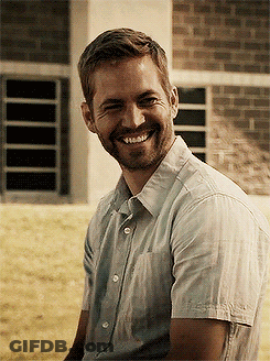 A Man With A Beard Wearing A White Shirt Is Smiling GIF
