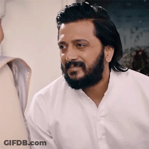 A Man With A Beard Wearing A White Shirt Is Smiling GIF