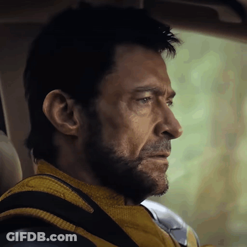 A Man With A Beard Wearing A Yellow Jacket And Black Gloves GIF
