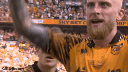 A Man With A Beard Wearing A Yellow Jersey With The Word Sky Bet On The Back GIF