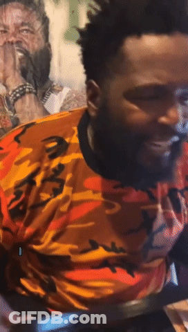 A Man With A Beard Wearing An Orange And Black Camo Shirt GIF