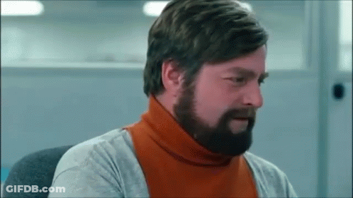 A Man With A Beard Wearing An Orange Turtleneck Sweater GIF