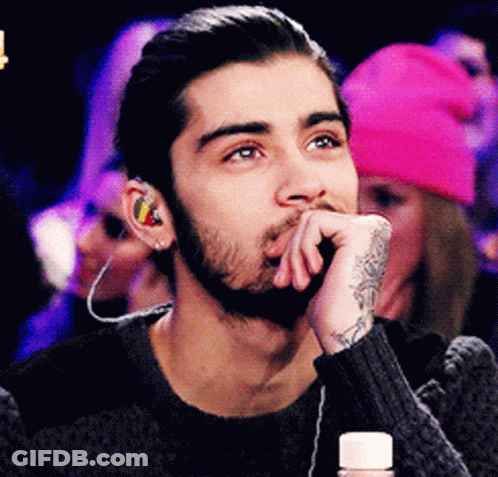 A Man With A Beard Wearing Ear Buds And A Tattoo On His Wrist GIF
