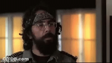 A Man With A Beard Wearing Glasses And A Bandana . GIF