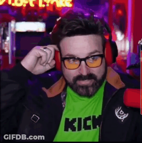 A Man With A Beard Wearing Glasses And A Green Shirt With The Word Kick On It . GIF