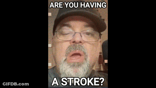 A Man With A Beard Wearing Glasses And A Hat Says Are You Having A Stroke GIF