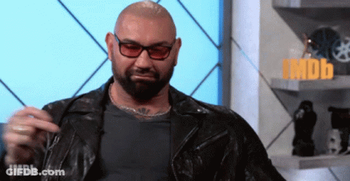 A Man With A Beard Wearing Glasses And A Leather Jacket Says Imdb On The Bottom Right GIF