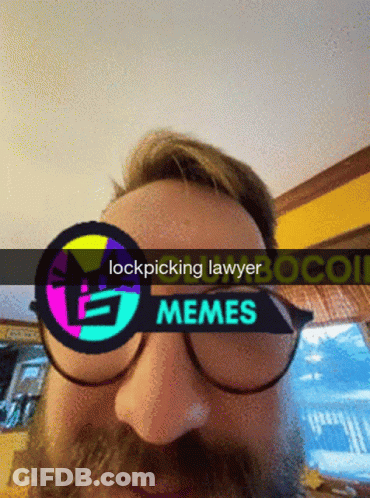 A Man With A Beard Wearing Glasses And A Sign That Says Lockpicking Lawyer GIF