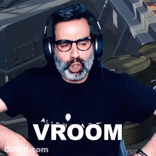 A Man With A Beard Wearing Headphones And A Black Shirt That Says Vroom GIF