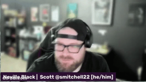 A Man With A Beard Wearing Headphones And A Hat With The Name Neville Black On The Bottom GIF