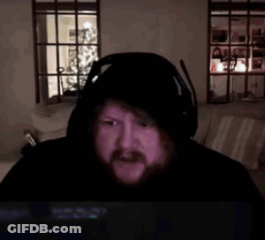 A Man With A Beard Wearing Headphones And A Hooded Jacket Is Laying In A Bed . GIF