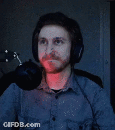 A Man With A Beard Wearing Headphones And A Microphone . GIF