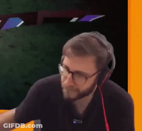 A Man With A Beard Wearing Headphones And Glasses Is Holding A Plastic Bag . GIF