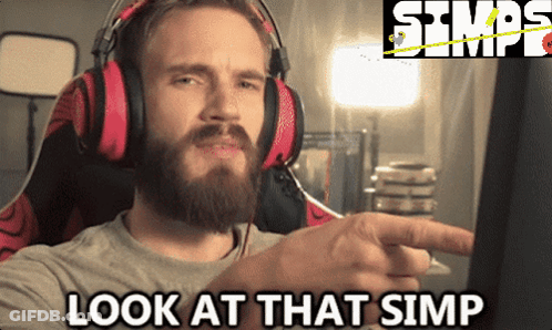 A Man With A Beard Wearing Headphones And Pointing At A Computer Screen With The Words Look At That Simp Below Him GIF