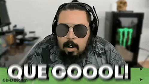 A Man With A Beard Wearing Headphones And Sunglasses Is Sitting In Front Of A Monster Energy Drink . GIF