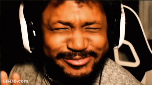 A Man With A Beard Wearing Headphones Is Making A Funny Face GIF