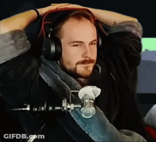 A Man With A Beard Wearing Headphones Is Sitting In Front Of A Microphone GIF