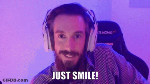 A Man With A Beard Wearing Headphones Is Smiling And Saying Just Smile . GIF