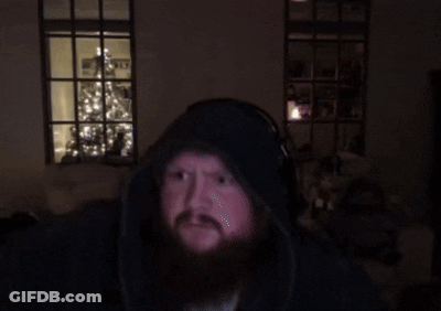 A Man With A Beard Wearing Headphones Looks At The Camera GIF