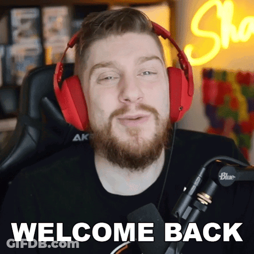 A Man With A Beard Wearing Red Headphones Says Welcome Back GIF