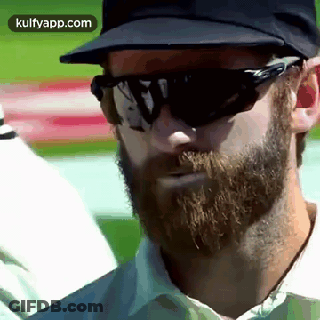 A Man With A Beard Wearing Sunglasses And A Baseball Cap . GIF
