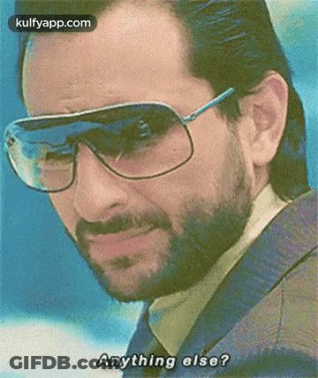 A Man With A Beard Wearing Sunglasses And A Jacket Is Asking Anything Else . GIF