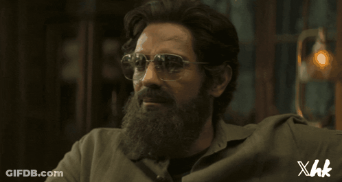 A Man With A Beard Wearing Sunglasses And A Shirt That Says Xhk On The Bottom GIF