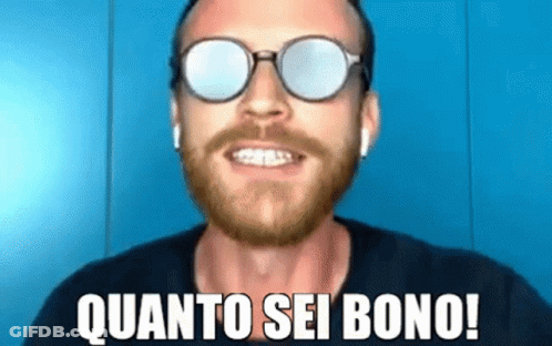 A Man With A Beard Wearing Sunglasses And Ear Buds Is Smiling And Saying Quanto Sei Bono ! GIF