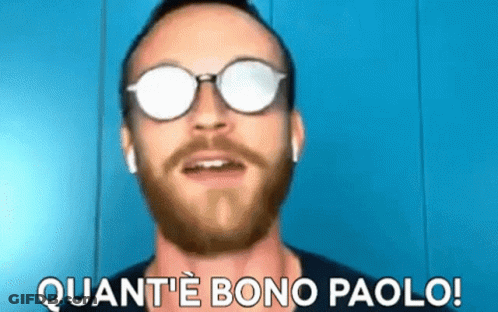 A Man With A Beard Wearing Sunglasses And Ear Buds Says Quant 'E Bono Paolo GIF