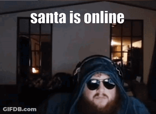 A Man With A Beard Wearing Sunglasses And Headphones With The Caption Santa Is Online GIF