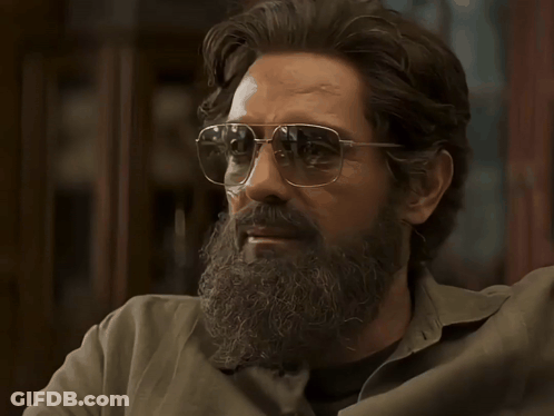 A Man With A Beard Wearing Sunglasses Looks To The Side GIF