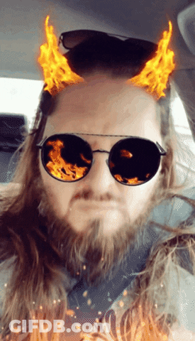 A Man With A Beard Wearing Sunglasses With Flames Coming Out Of Them GIF