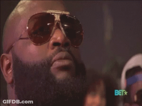 A Man With A Beard Wearing Sunglasses With The Bet Logo In The Background GIF