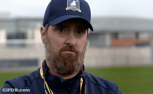 A Man With A Beard Wears A Blue Hat With A Deer On The Front GIF